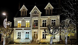 Photographie en couleurs et en pleine nuit de la façade d'un bâtiment public.