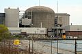 A single unit of the Pickering Nuclear Generating Station, showing a slightly different shape from a typical PWR containment, which is mostly due to the larger footprint required by the CANDU design. The vacuum building can be seen partly obscured on the right.