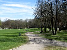 mehrere Wege führen in geschwungenen Formen durch die Tallandschaft. Das Bild zeigt den Park im Frühling, die Bäume sind noch ohne Blätter