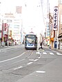 安全地帯のない電停で、乗客が路上を渡って乗車する様子（中納言停留場）