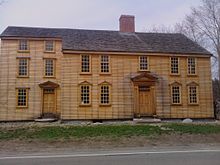 La ferme de Barrett, un long bâtiment en bois avec de nombreuses fenêtres.