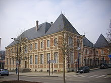 Photographie d'un bâtiment d'angle en brique rouge.