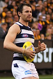 Male athlete holds a football during a game