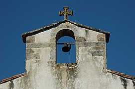 Photographie d’un clocher-mur sur fond de ciel d’azur.