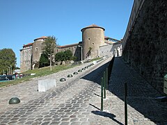 Vue d’une rue pavée montant vers deux tours de garde.