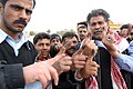 Iraqi police show of their ink-stained index fingers – proof that they visited the polls to cast their ballot in Iraq’s historic parliamentary elections, 2005