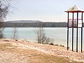 Altwarmbüchener See mit Badestrand, dahinter der Nordberg der Deponie Hannover-Lahe