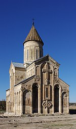 Stone church with a prominent cross on one of the walls