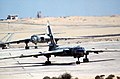 Dvojice egyptských proudových bombardérů typu Tupolev Tu-16 na stojánce letiště během cvičení Bright Star. Vlevo je vidět ocas vraku letounu stejného typu, 1980