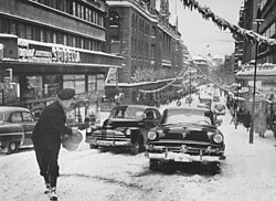 Hamngatan österut vid "Hamngatsbacken" en vinterdag 1955 och samma ställe en vinterdag 2010, "Hamngatsbacken" grävdes bort 1967–1968. Till vänster syns Hästskopalatset och NK, den enda bebyggelsen i den forna backen som överlevde Norrmalmsregleringen.