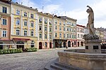 Old colourful town houses and a fountain with a statue in front