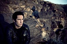 A man sitting in front of a field of craggy rocks