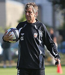 Photographie de Christian Gourcuff, un ballon à la main.