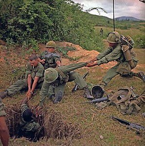 An infantryman is lowered into a tunnel during Operation Oregon