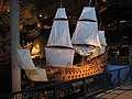 English: A model of the 17t century warship Vasa on display at the Vasa Museum with the actual ship in the background.