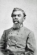 Black and white photo of an older bearded man in a gray military uniform with two rows of buttons.