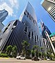 Ground-level view of a 50-storey building, distinct architecture features modern hole designs with trees in them.