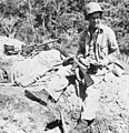 During the lull in the Battle for Henderson Field, a Marine machine gunner takes a break for coffee, with his sub-machine gun on his knee and his .30-caliber light machine gun in position.