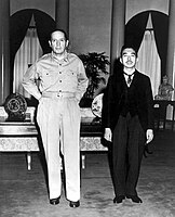 El emperador japonés Hiro Hito empequeñecido físicamente por el general Douglas MacArthur, ya despojado de su divinidad protocolaria tras la derrota de 1945. El expansionismo militarista japonés no había tenido una identificación ideológica con los fascismos europeos, sino más bien una relación estratégica por la convergencia de intereses.