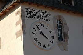 Photographie d’une horloge murale avec une inscription en basque.