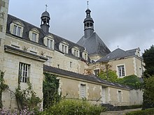 Photographie d'un bâtiment en pierre de tuffeau et toit d'ardoise.