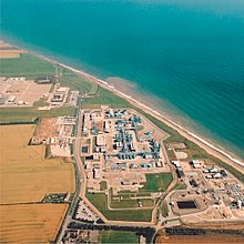 Aerial view of the gridiron arrangement of buildings and pipes beside the curving Yorkshire sea coast