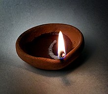 A small bowl with a lighted wick in it