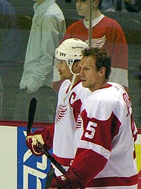 Photo de profil de Lidstrom portant le numéro 5 des Red Wings devant Yzerman portant le C de capitaine.