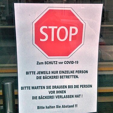 A sign prohibiting more than one person at a time from entering a bakery in Germany.