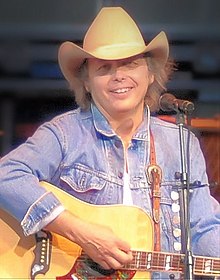 Country music singer Dwight Yoakam, singing while strumming a guitar