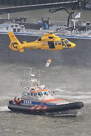 photo d'un hélicoptère manœuvrant au-dessus d'un navire