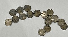 a grouping of small silver coins, all very worn, holed and joined together by rings