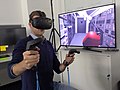 Image 3Researchers with the European Space Agency in Darmstadt, Germany, equipped with a VR headset and motion controllers, demonstrating how astronauts might use virtual reality in the future to train to extinguish a fire inside a lunar habitat (from Virtual reality)