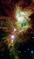 NGC 2264 en infrarouge par le télescope spatial Spitzer. En rose, des étoiles nouvellement formées. On a donné le nom d'amas du Flocon de Neige (en) au groupe d'étoiles que l'on voit sur cette photo.