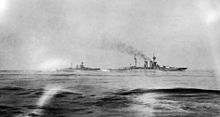 Britské bitevní lodě HMS Warspite a HMS Malaya plující na horizontu během bitvy u Jutska.