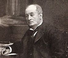 Head and upper body of a middle-aged man with receding hair, clean shaven, wearing a wing collar with tie, looking left. He is seated at a table, with a pen in his right hand.