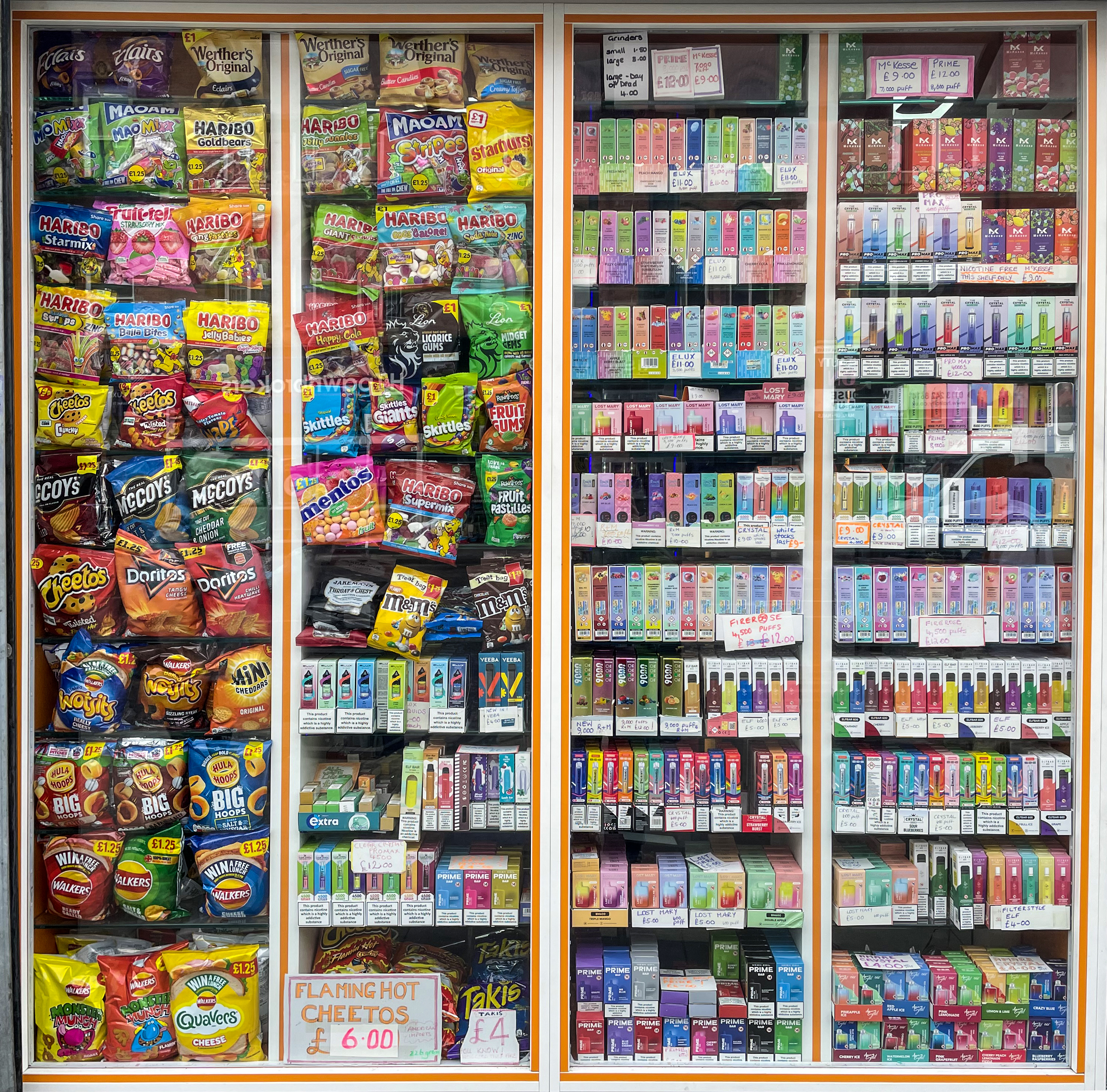 Colourful vapes displayed next to snacks at a newsagents stand