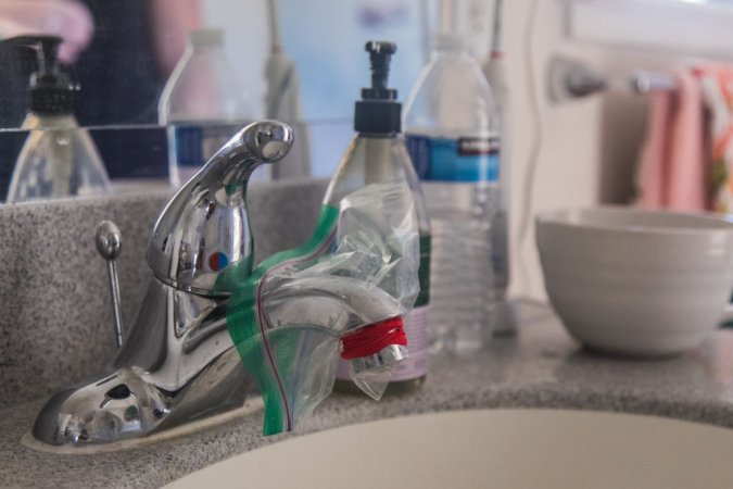 HONOLULU, HI - DECEMBER 11: A ziploc bag is used to cover Jamie Williams' bathroom faucet at her Aliamanu Military Reservation home in Honolulu, HI on December 11, 2021. Williams, like many other Hawaii residents, has been forced to contain the fuel leaking into their water supply. (Photo by Marie Eriel Hobro/For the Washington Post)